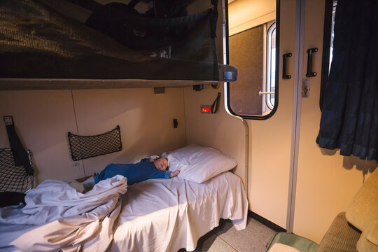 Toddler boy sleeping on bed in sleeper train