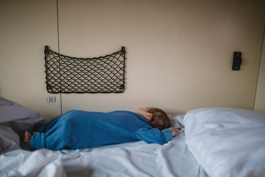 Side view of boy sleeping on bed in sleeper train