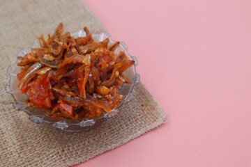 Jengki anchovies or split anchovies (Stolephorus indicus) cooked in spicy sauce in a glass bowl. With a close look.
