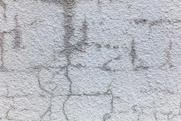 A wall with a lot of cracks and holes