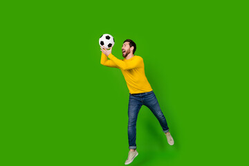 Full body photo of attractive young man jump catch soccer ball dressed stylish yellow clothes...