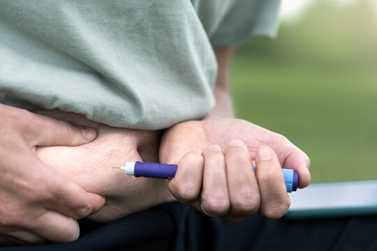 Midsection of man injecting diabetes insulin in stomach