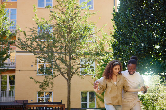 Man teaching salsa dance to woman in building back yard