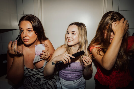 Female friends getting ready for party at home