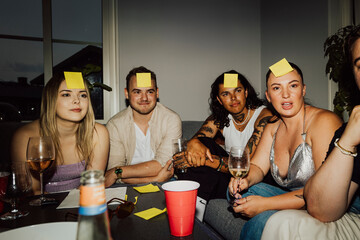 Group of friends playing guessing games during home party