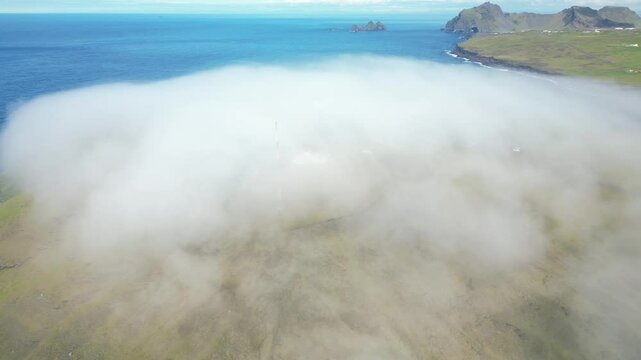 Aerial view of dense mist cover the southern remote Icelandic landmark, touristic Vestmannaeyjar