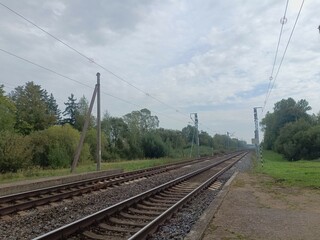 Two way railroad tracks in countryside. Two railway tracks. Cloudy day. Countryside. Fields and...