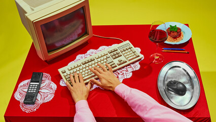 Close-up of hand using computer mouse placed on silver platter, with spaghetti resting on keyboard....