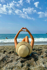 Girl showing heart at the beach

