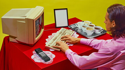 Person typing at vintage computer, with tray of multiple cups of coffee beside them. Retro setting...