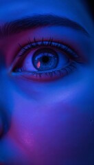 Fototapeta premium Close-up of a mesmerizing blue eye with vibrant lighting, detailed facial features, artistic portrait