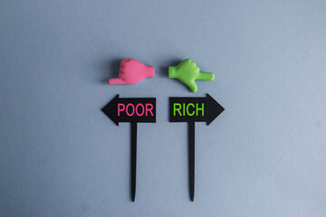 Rich and Poor symbol. BLACK ARROW-SHAPED PLAQUES WITH THE WORDS Rich or Poor. HANDS POINTING IN...