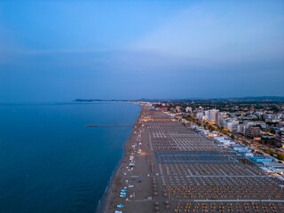Rimini, Italy, Adriatic Sea: An elevated shot reveals a coastal city at dusk, where a sprawling...