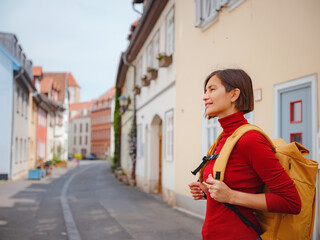 Tourist woman explores beautiful city of Erfurt, wandering through its historic streets, admiring...