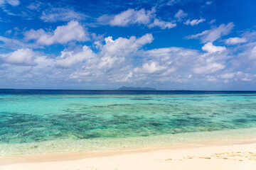 View of mountainous Boheydulang Island (Pulau Bohidulong) as seen from Timba Timba Island (Timba-Timba). Beautiful golden white sand, turquoise water and blue sky.