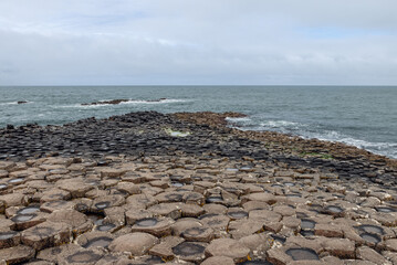 A promontory of hexagonal basalt columns extends into the Atlantic Ocean at Giant Causeway in...