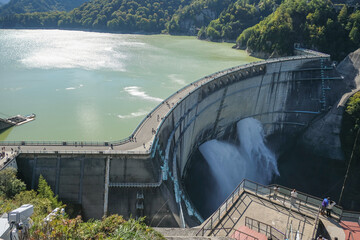 Kurobe Dam, Tateyama, Toyama, Chubu, Japan A scenic view of a dam, with water flowing over the edge