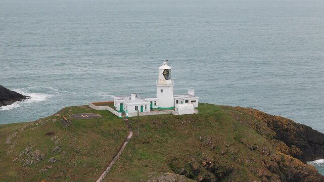 Strumble head lighthouse aerial view of stone tower on Pembrokeshire rugged island mainland