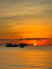 Sunset boat floating over the peaceful tropical sea