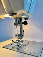 Modern sewing machine presser foot with linen fabric and thread, closeup, copy space. Sewing process clothes, curtains, upholstery. Business, hobby, handmade, zero waste, recycling, repair concept