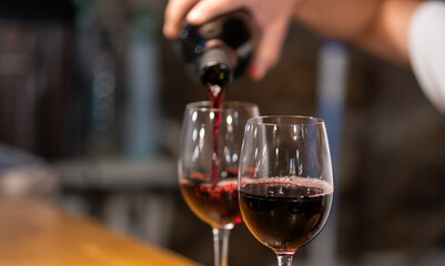 Man pouring red wine into a glass 