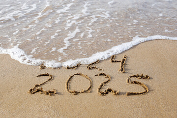 2024, 2025 years written on sandy beach sea. Wave washes away 2024. Happy New Year!