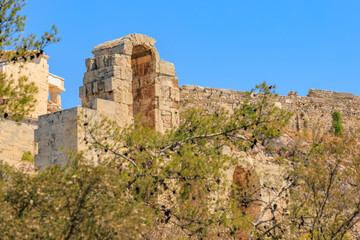 Fototapeta premium A stone building with a large archway and a tree in front of it, Acropolis in Athens
