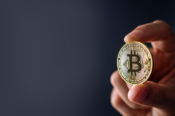 Bitcoin Blockchain Technology and Cryptocurrency. Hand holding bitcoin for Digital Finance and trading concept.