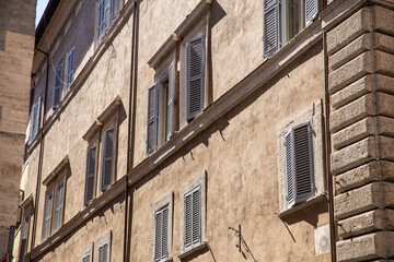 Sunlit Facade of Historic Building with Wooden Shutters
