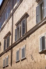 Sunlit Facade of Historic Building with Wooden Shutters