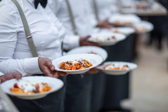 Waiters Serving Freshly Plated Pasta with Cheese Topping - Powered by Adobe