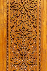 Fragment of an ancient carved wooden door. Ornate background.