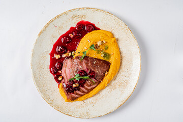 duck with cherry sauce on pumpkin puree