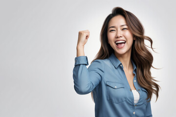 Cute Asian woman with long hair raising a fist in a 'yes' gesture on a white background.