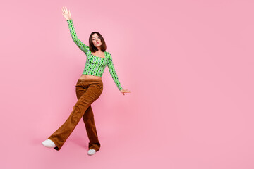 Photo of lovely adorable woman wear green stylish clothes dance empty space isolated on pink color...