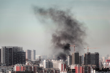 Smoke over the city after air strike, clouds of black smoke blue sky billow over the town