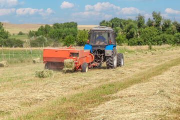 Agricultural work. Hay harvesting. Tractor collects straw into bales