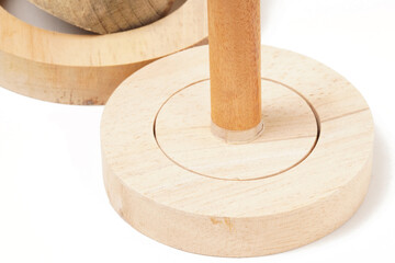 A wooden tool used to flatten donut dough, consisting of two parts: a ring to hold the dough and a round surface to press it flat. Photographed on a white background.