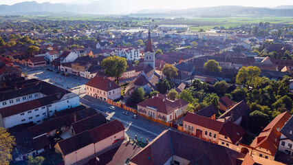 Aerial view of Rasnov Castle area in Romania during a bright sunny day with greenery