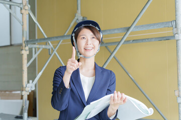 建設現場で図面を見る女性ビジネスマン（スーツ・工事・現場監督）