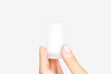 female hand holding mineral potassium alum crystal stick. natural deodorants concept