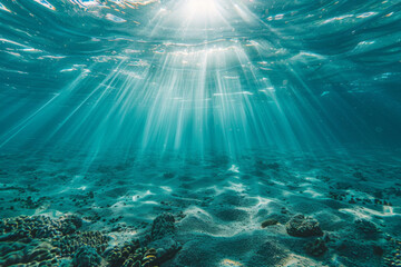 Obraz premium Underwater view of water with sunlight shining through the surface, creating a scene with light rays and ripples.