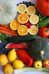 Various seasonal fruits and vegetables on white background. Summer and fall produce. Top view.