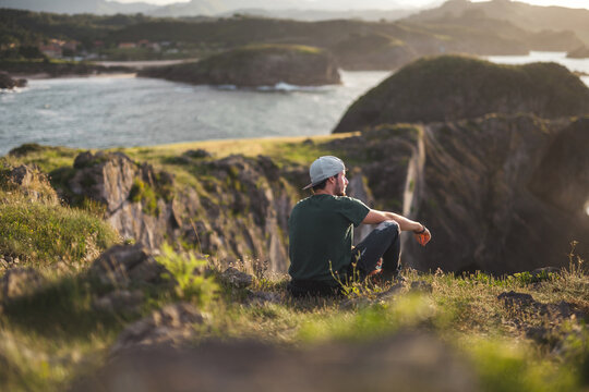 Man enjoys serene cliffside view in Asturias, Spain