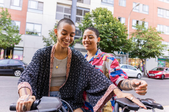 Joyful Hispanic lesbian couple enjoying time together in city