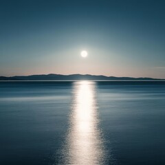 Fototapeta premium A tranquil scene of a full moon rising over a calm, still body of water. The moon's reflection casts a luminous path across the water.
