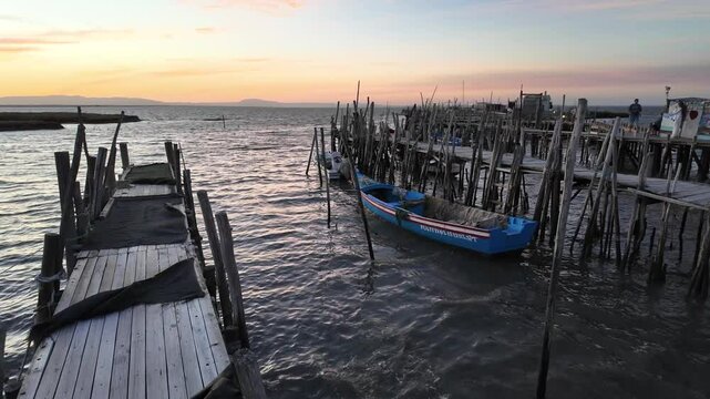 Porto Palafitico in Comporta, Portugal, featuring traditional wooden stilts and rustic fishing boats along the winding pier, capturing the charm of this unique harbor on a calm 