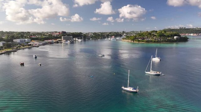 Port Vila, Efate, Vanuatu - A Coastal Tropical City With Boats and Yachts Anchored in the Harbor Beneath a Sky Filled With Fluffy Clouds - Aerial Drone Shot