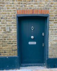 Blue door with silver knob and brown old bricks