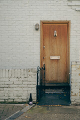 Brown Door with the letter A with white brick and a champagne bottle